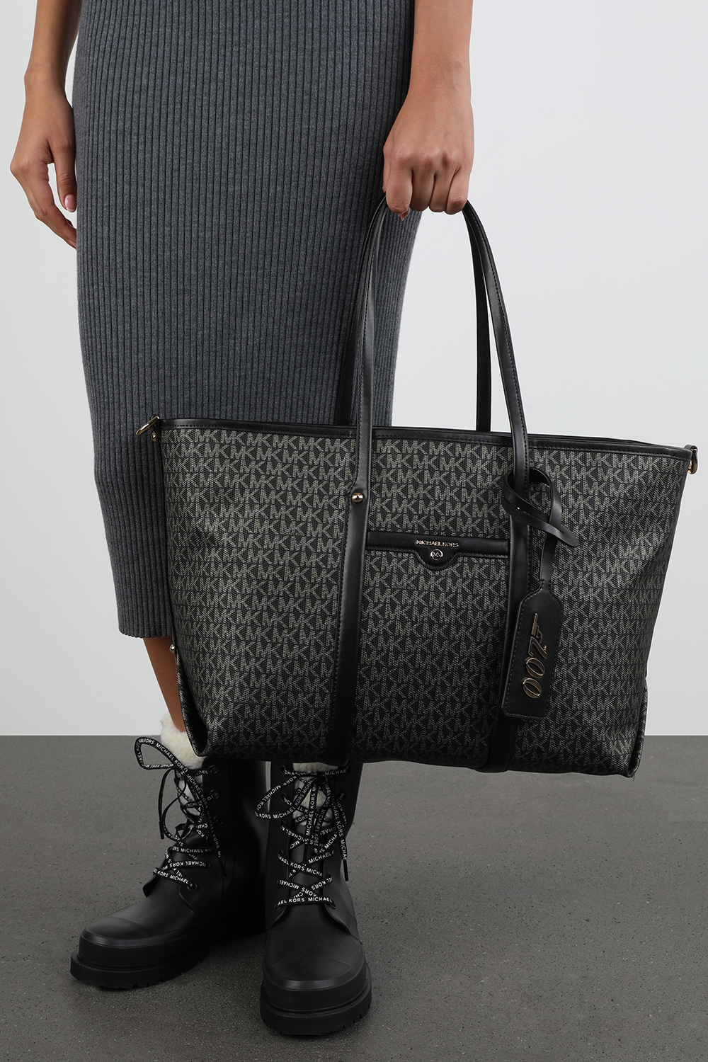 תמונת כל הלוק של מייקל קורס x 007 תיק נשיאה בק בצבע שחור מונוגרמי 